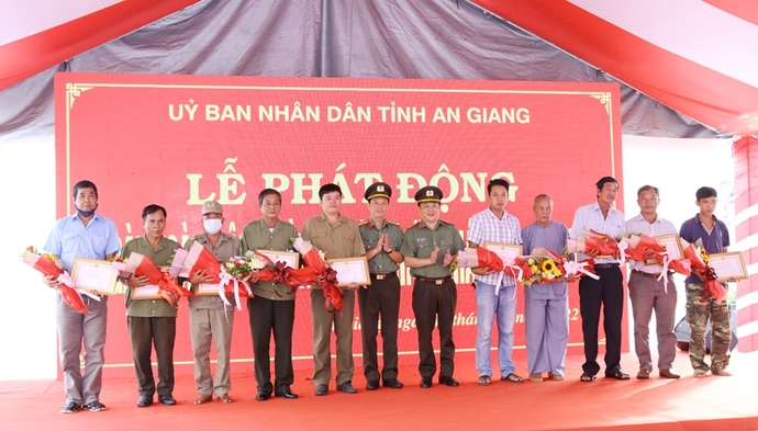 Đại tá Lâm Phước Nguyên - Giám đốc Công an tỉnh và Đại tá Lê Phú Thạnh - Phó Giám đốc Công an tỉnh trao Giấy khen và hoa cho các cá nhân có thành tích xuất sắc trong phong trào toàn dân tham gia PCCC. Ảnh: M.Triết - T.Tầm.