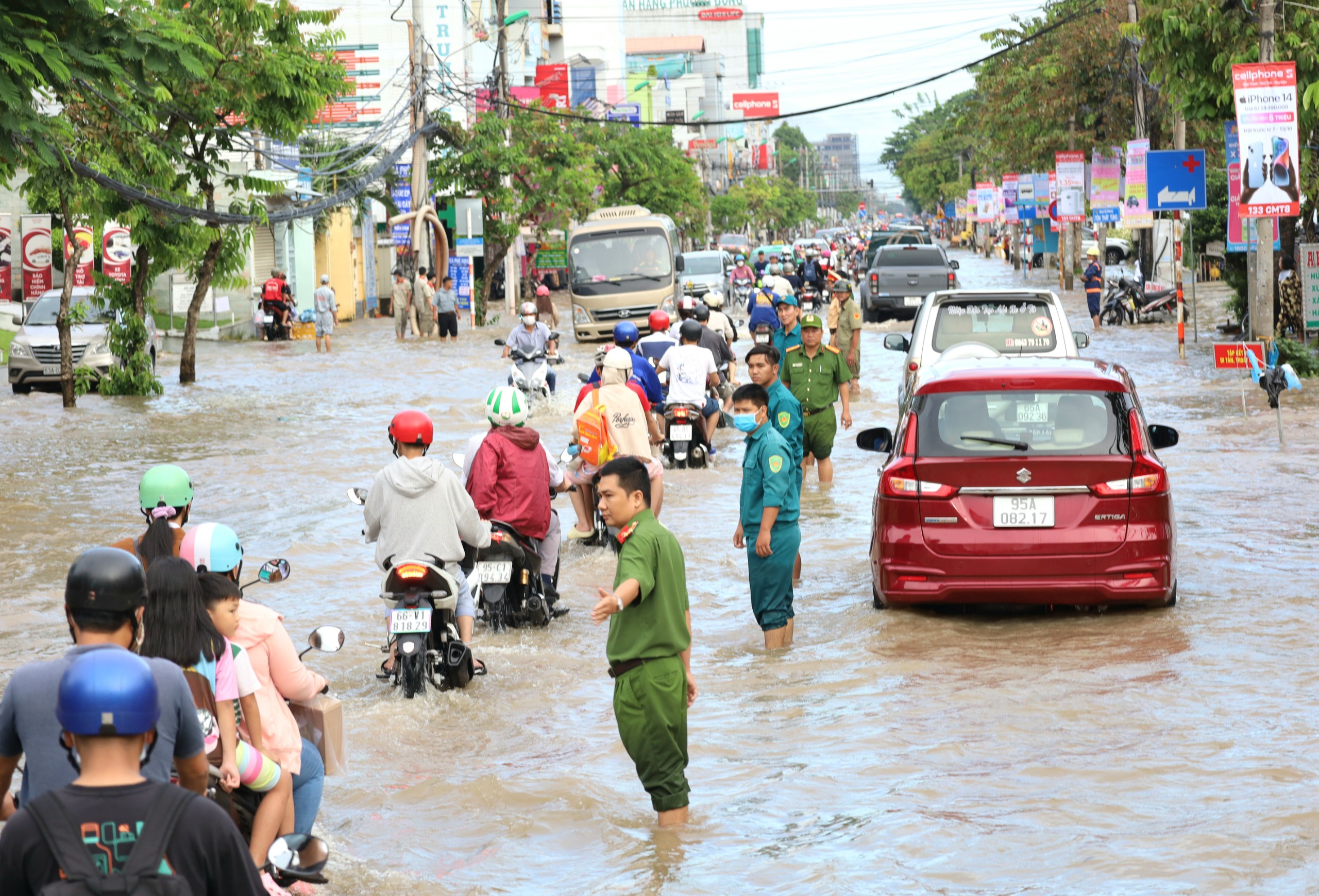 Lực lượng công an phân luồng để người dân tham gia giao thông di chuyển an toàn qua đoạn ngập sâu.