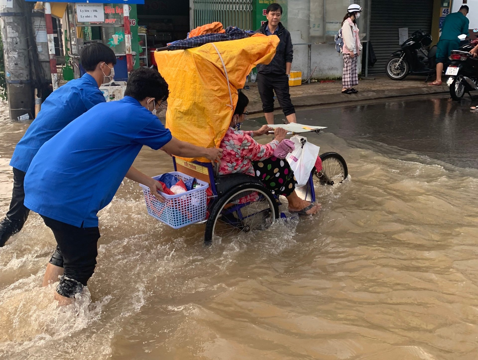 Hỗ trợ người khuyết tật vượt qua điểm ngập sâu.