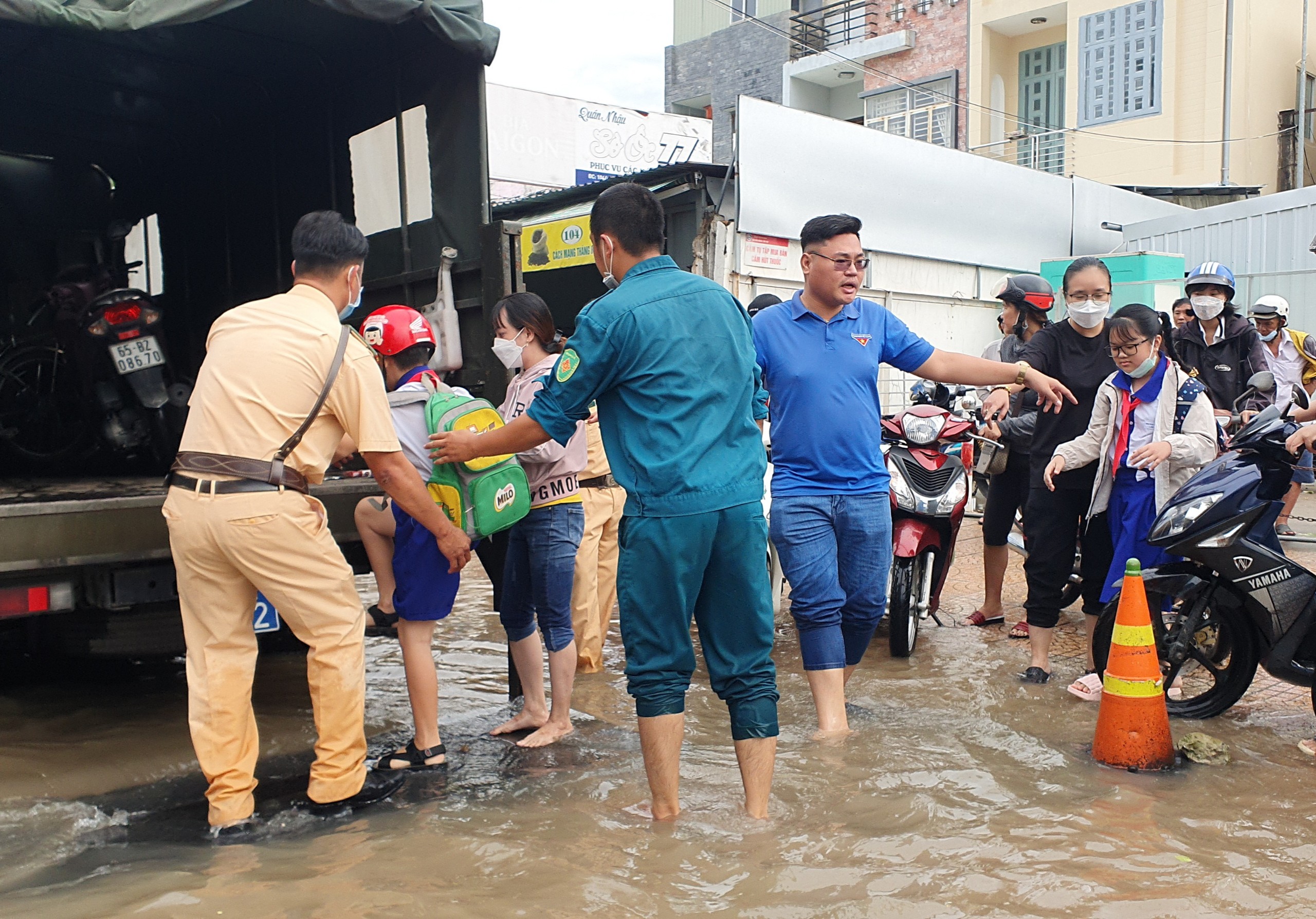 Đoàn thanh niên phối hợp cùng công an, quân sự hỗ trợ đưa học sinh, người dân đi qua các điểm ngập sâu.