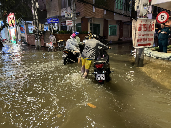 Nhiều phương tiện bị chết máy do nước ngập, người dân dẫn xe dưới trời mưa lớn.