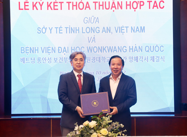 Chủ tịch UBND tỉnh – Nguyễn Văn Út (bên phải) tặng quà lưu niệm cho Giám đốc Bệnh viện Đại học Wonkwang - Seo Il Young. (Ảnh: longangov).