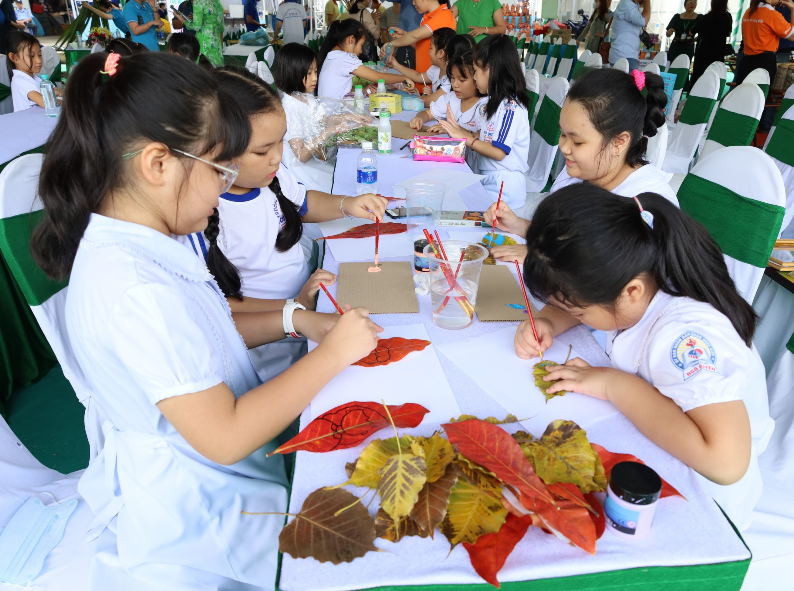 Các em học sinh Trường Tiểu học Ngô Quyền, quận Ninh Kiều tham gia thi vẽ trên lá và sáng tạo những bức tranh được làm từ lá.