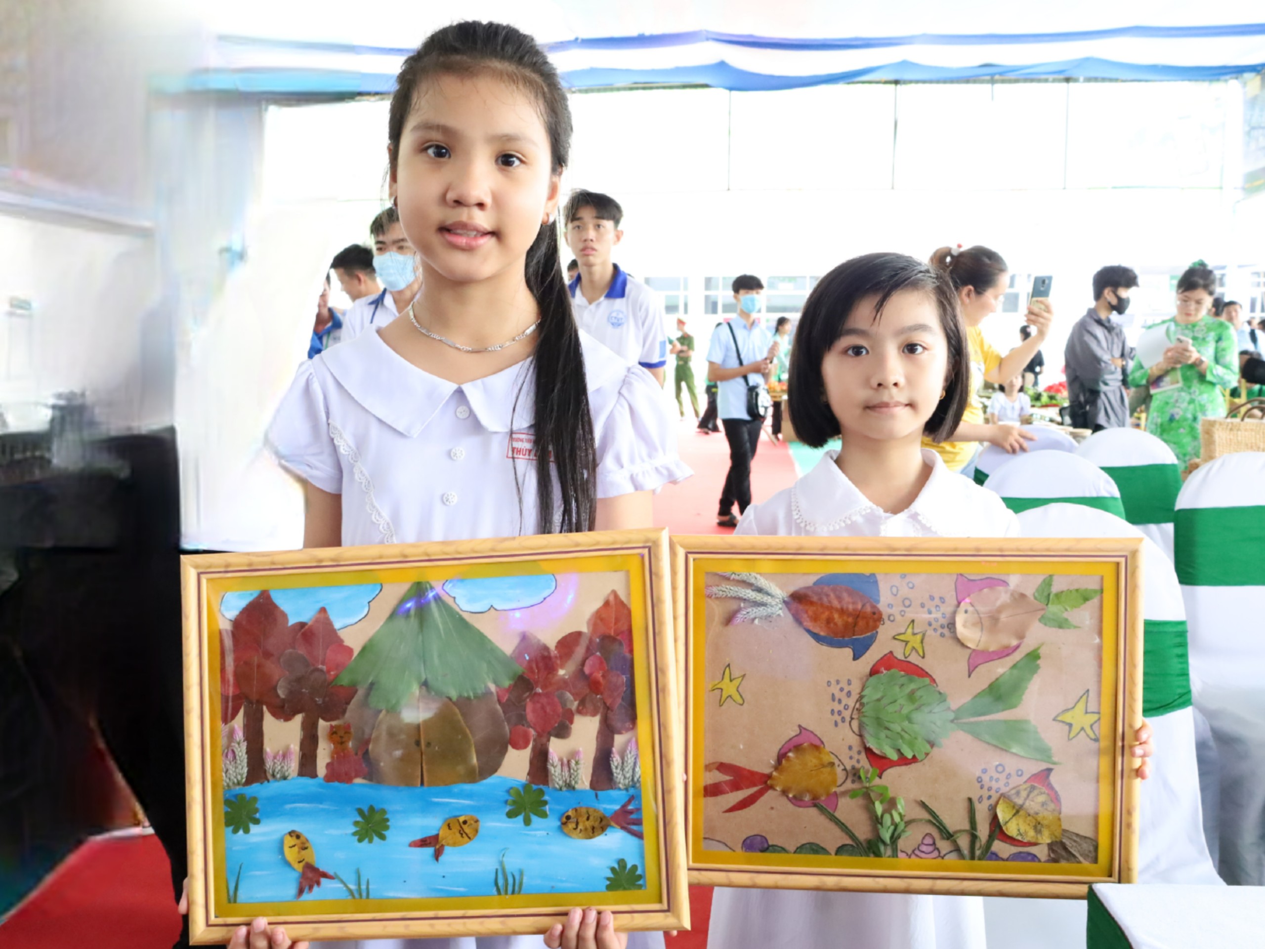Các em học sinh Trường Tiểu học Ngô Quyền, quận Ninh Kiều với tác phẩm vẽ trên lá và sáng tạo những bức tranh được làm từ lá.