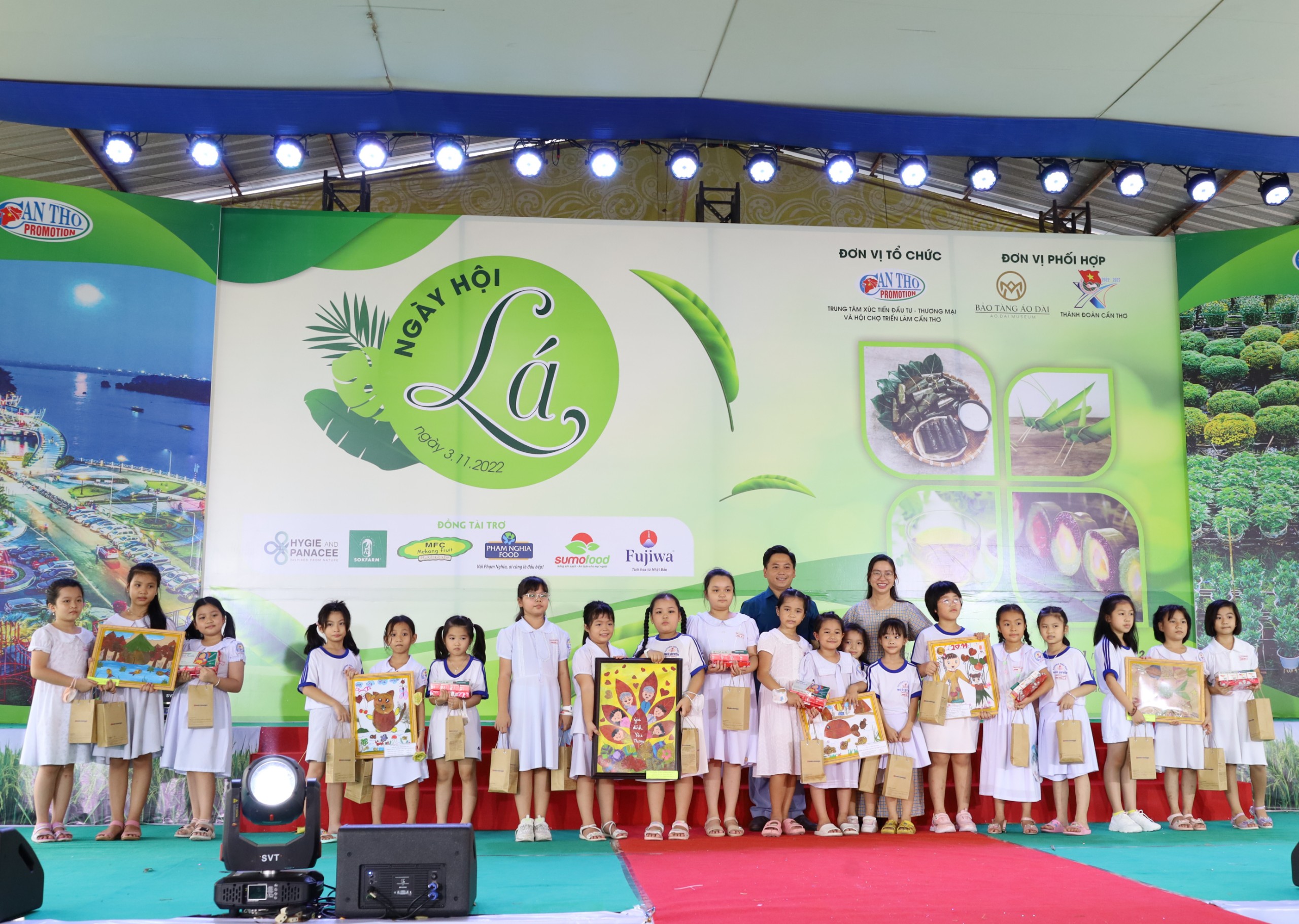 Ban tổ chức trao quà cho các em học sinh Trường Tiểu học Ngô Quyền, quận Ninh Kiều tham gia vẽ trên lá và sáng tạo những bức tranh được làm từ lá kêu gọi bảo vệ môi trường.