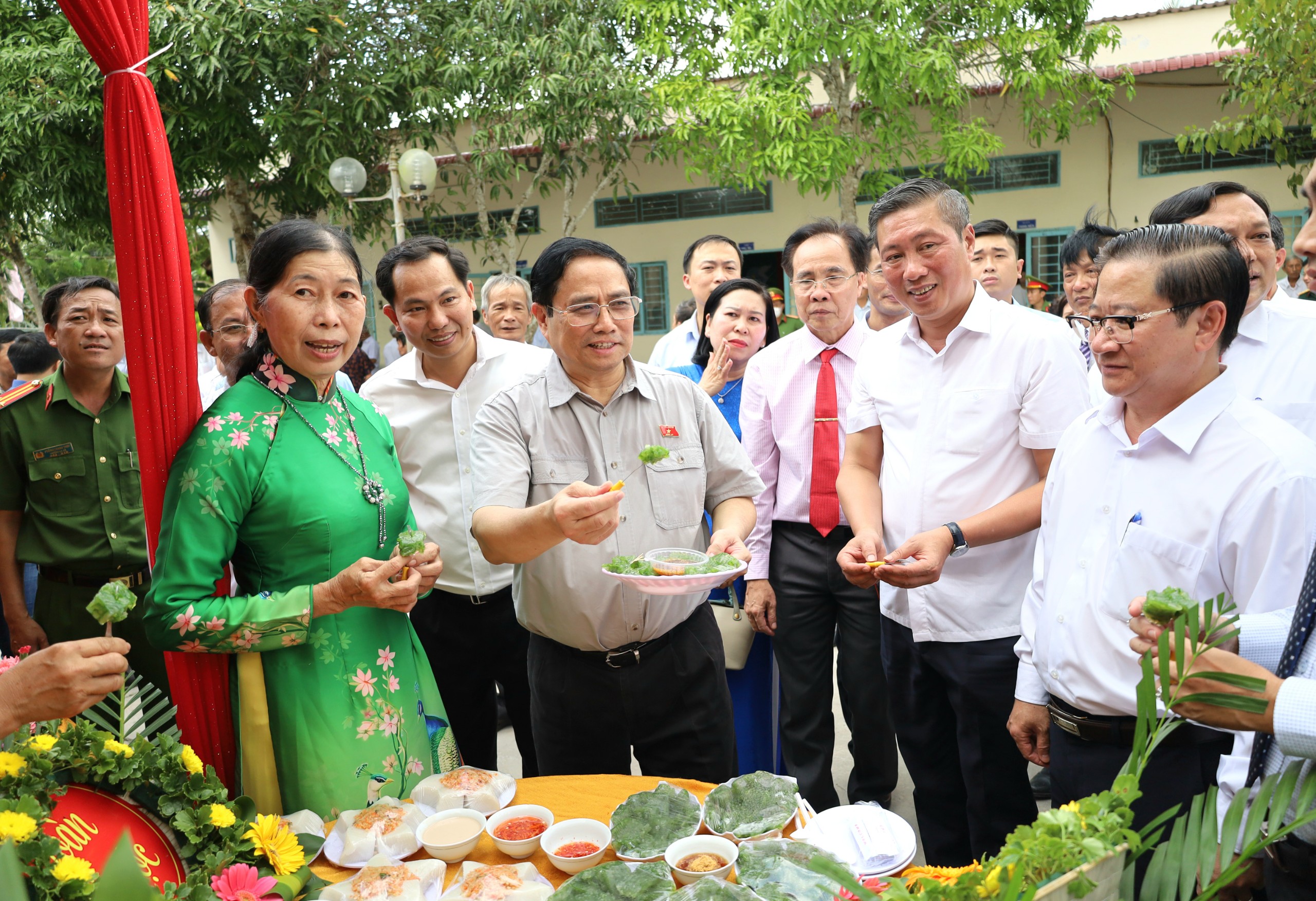 Ông Phạm Minh Chính - Ủy viên Bộ Chính trị, Thủ tướng Chính phủ cùng các đại biểu thưởng thức các loại bánh dân gian đặc sản của huyện Phong Điền.