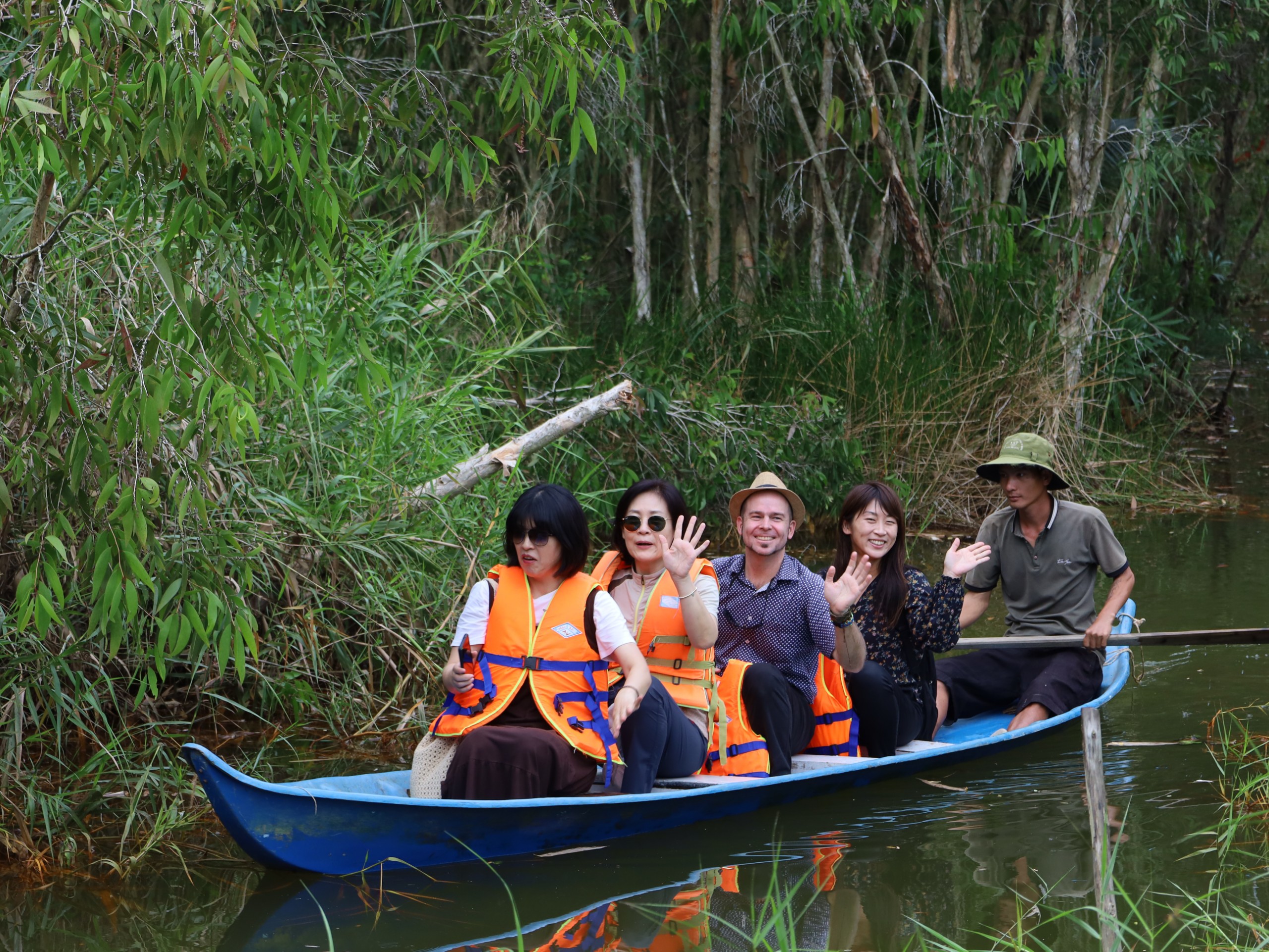 Du khách nước ngoài thích thú khi được trải nghiệm đi xuồng trong rừng tràm tại Khu du lịch sinh thái Hoa Rừng U Minh.