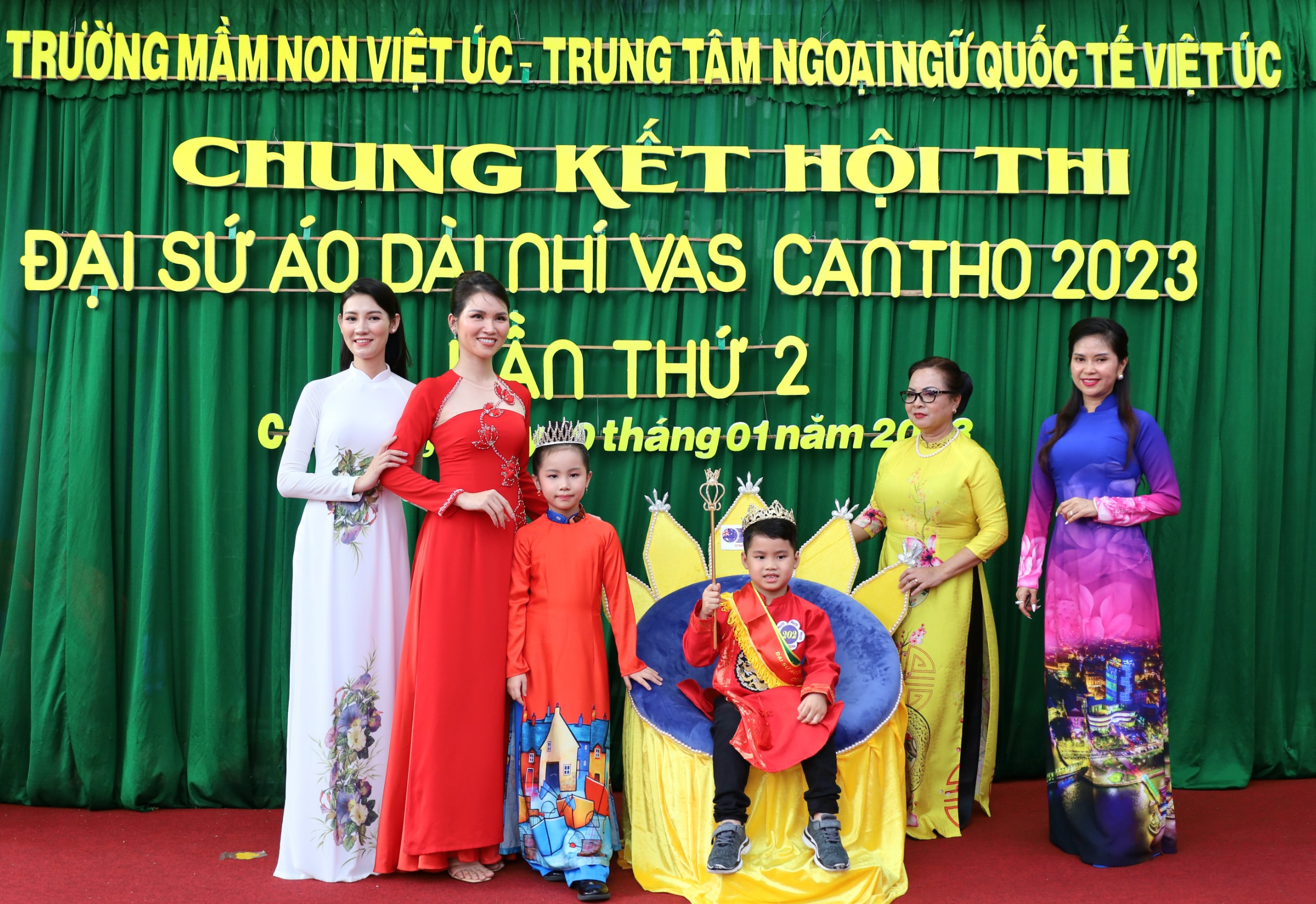 Hoa hậu Vũ Lan Phương - Hoa hậu Tây Đô 2007 (bìa trái); Á hậu Hà Bích Ngọc - Á hậu Doanh nhân Việt Nam Quốc tế 2022; Cô Hà Kim Thoa - Chủ tịch Hội đồng quản trị trường Mầm non Việt Úc; bà Lê Thị Mộng Thúy - UV Ban đối ngoại Dự án quảng bá Áo dài Việt Nam (bìa phải) và bé Trang Tường Vi - Quán quân áo dài nhí VAS mùa 1 trao vương miện và quyền trượng cho Quán quân Trần Quang Lộc.