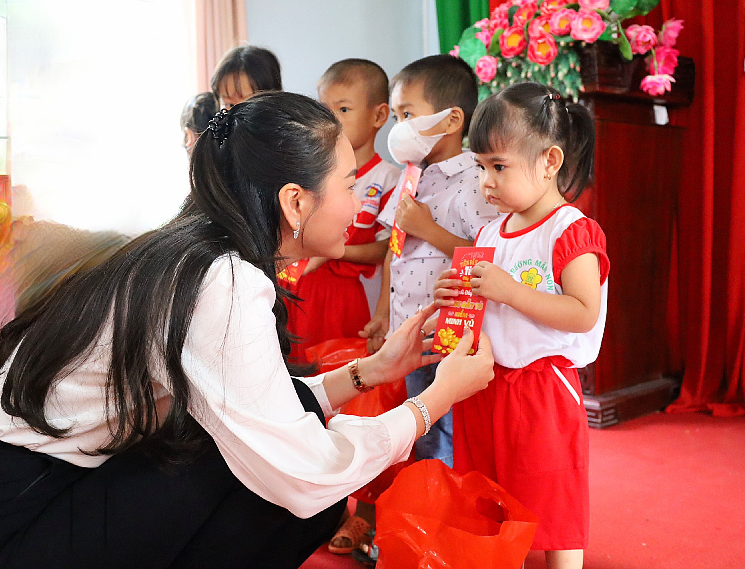 Chị Lê Minh Thy Thơ – Giám đốc Công Ty TNHH Kinh doanh Vàng - Đá quý Minh Vũ (Minh Vũ Jewelry) trao quà cho các em thiếu nhi.