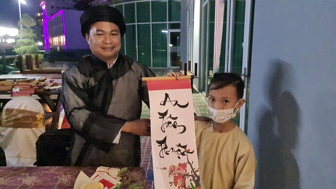Ông Trần Ngọc Ngà - Phó Giám đốc Khách sạn Ninh Kiều Riverside tặng chữ cho các bé thiếu nhi.