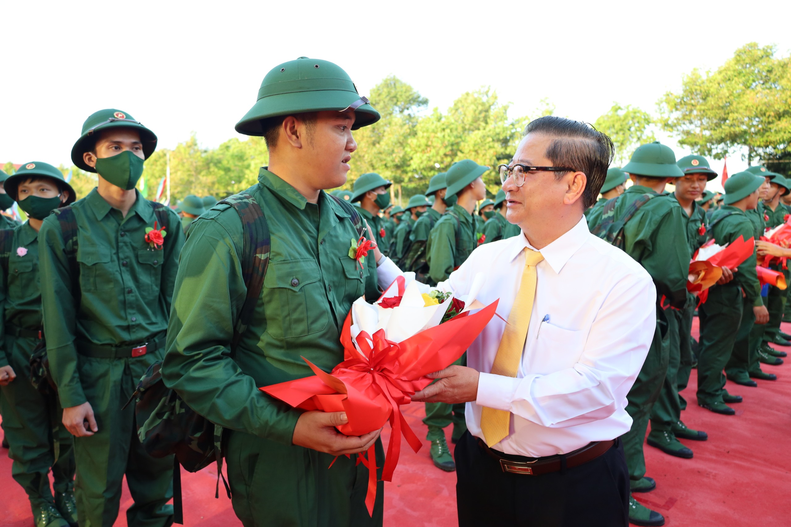 Ông Trần Việt Trường - Phó Bí thư Thành ủy, Chủ tịch UBND thành phố, Chủ tịch Hội đồng NVQS TP. Cần Thơ tặng hoa, động viên thanh niên lên đường nhập ngũ.