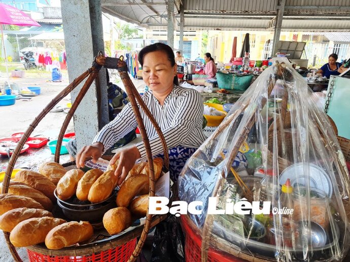 Chị Tô Thị Quy và gánh bánh mì mưu sinh. Ảnh: T.Q