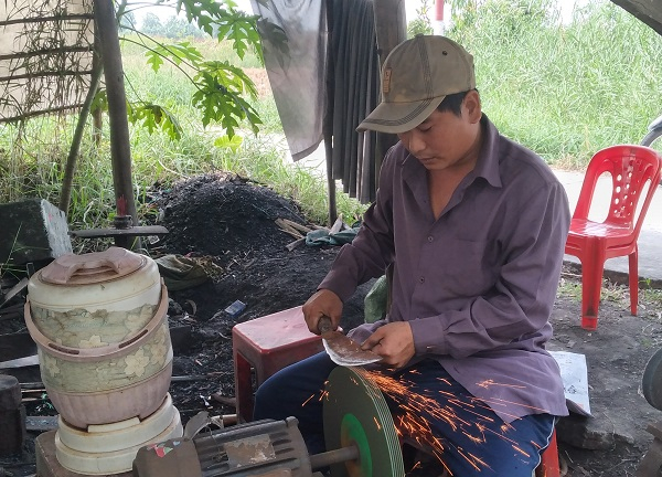 Anh Tý đang mài, sửa chữa dao cho khách hàng.