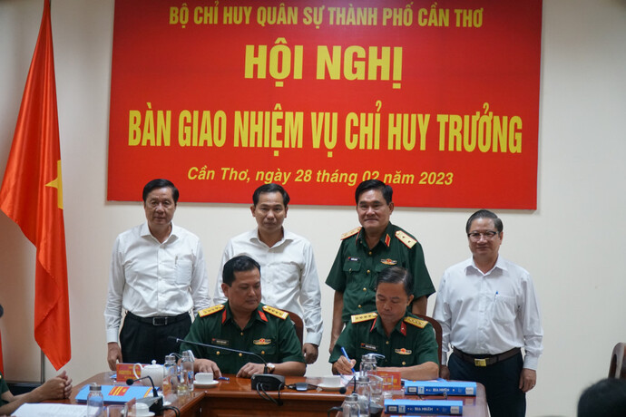 Đại tá Chiêm Thống Nhất (ngồi góc trái) và Đại tá Huỳnh Văn Phương (ngồi góc phải) ký biên bản bàn giao nhiệm vụ dưới sự chứng kiến của Bộ Tư lệnh Quân khu 9 và lãnh đạo Thành ủy. Ảnh: Phạm Trung.