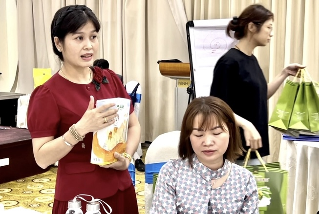 Bà Nguyễn Chúc Triều Anh, Giám đốc Công ty TAC giới thiệu sản phẩm trà mãng cầu Long Giang và gạo A An của tập đoàn Tân Long trước các vị khách quí.