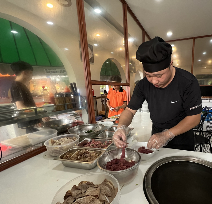 Đầu bếp phở Lý Quốc Sư tại quán cafe Trung Đông (Cần Thơ) đang nhanh tay cho ra tô phở phục vụ khách hàng.