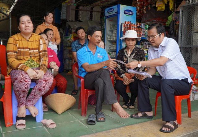 Ông Cao Thanh Xuân - Bí thư Huyện ủy Thanh Bình (bìa phải) thăm hỏi, trao tiền hỗ trợ cho các hộ dân bị thiệt hại