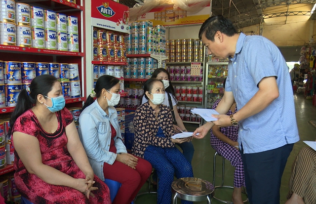 Chủ tịch Uỷ ban nhân dân tỉnh Phạm Thiện Nghĩa trao tiền hỗ trợ các tiểu thương bị thiệt hại.