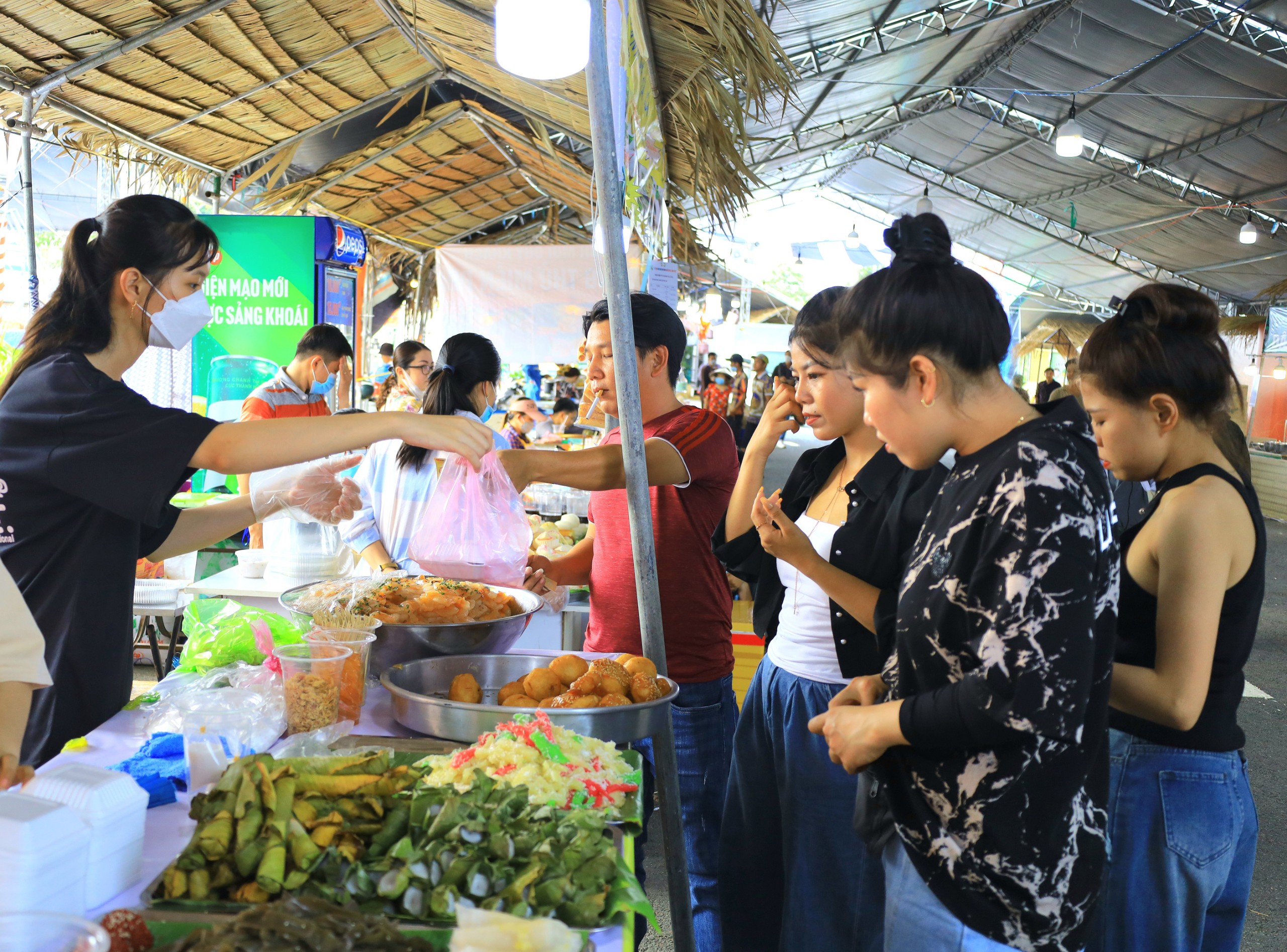 Khách tham quan thưởng thức các loại bánh dân gian tại lễ hội.