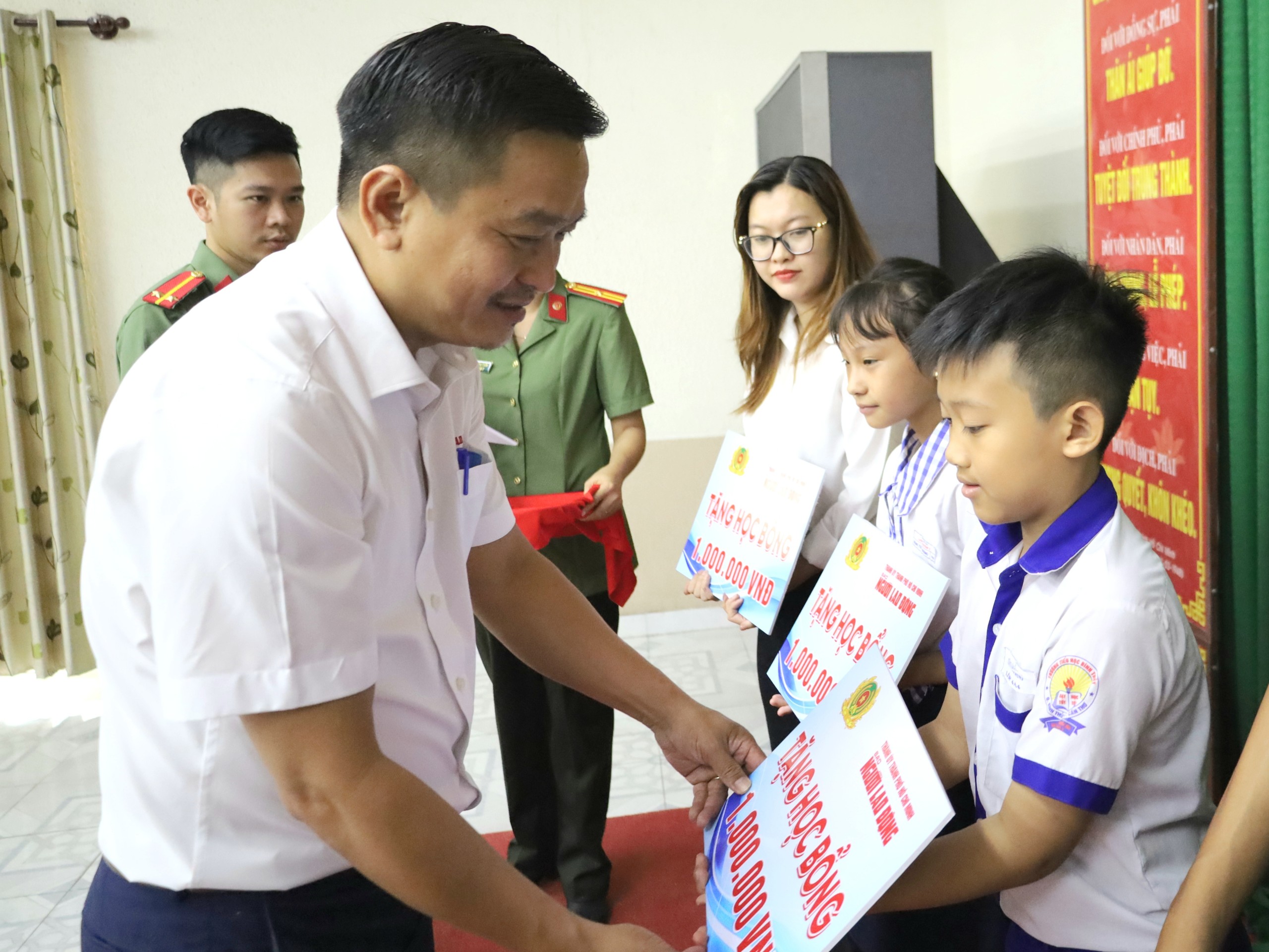 Ông Trần Công Tuấn - Phụ trách Văn phòng đại diện Báo Người lao động khu vực ĐBSCL trao tặng học bổng cho các em học sinh.