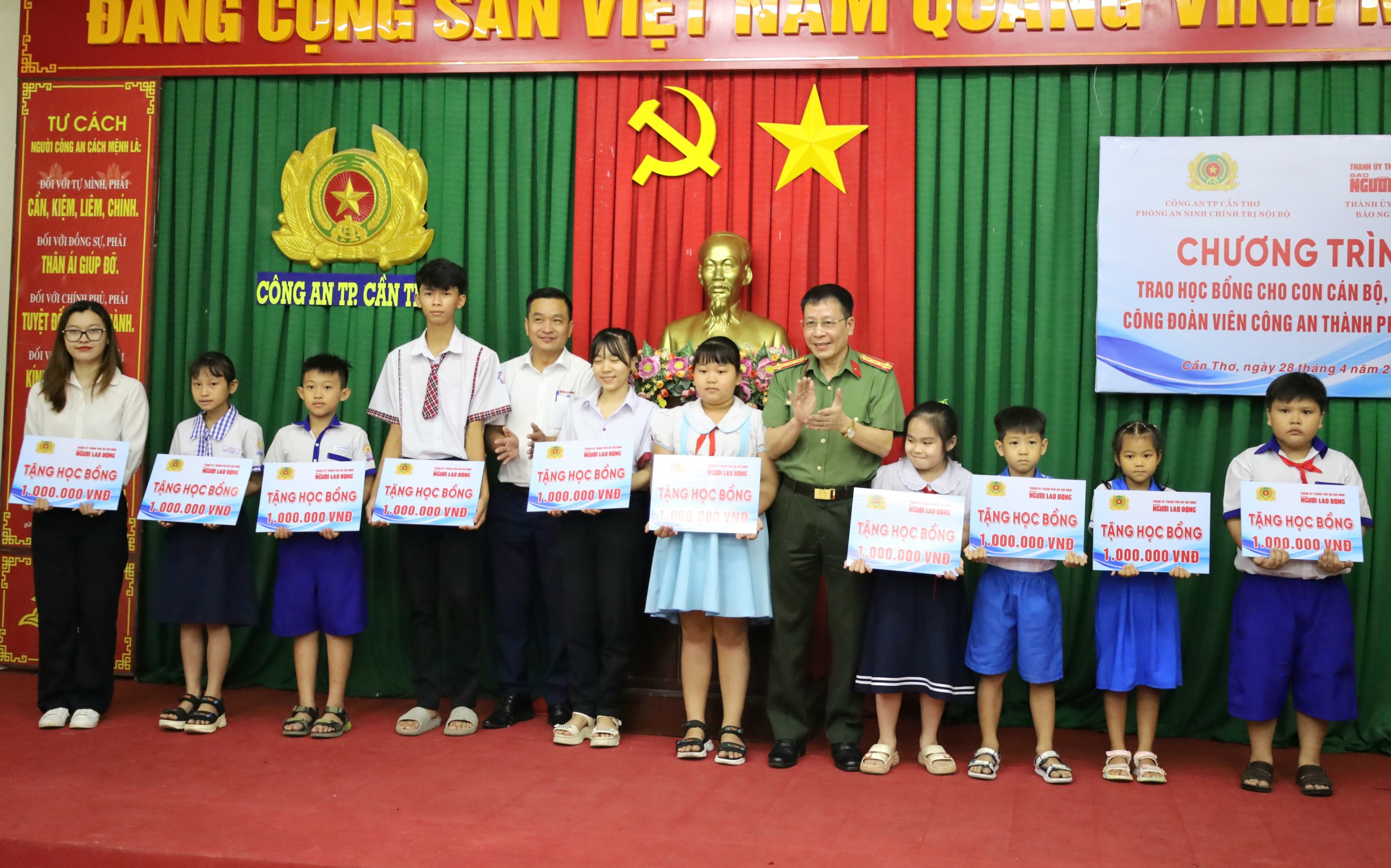 Đại tá Vũ Thành Thức – Phó Giám đốc Công an TP. Cần Thơ và ông Trần Công Tuấn - Phụ trách Văn phòng đại diện Báo Người lao động khu vực ĐBSCL trao tặng học bổng cho các em học sinh.