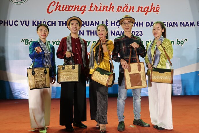 Đại diện công ty TNHH Đầu tư TMDV Mekong Long Ngân và anh Bùi Thành Được duyên dáng bên những chiếc túi xách cỏ bàng được chế tác công phu, tỉ mẫn.