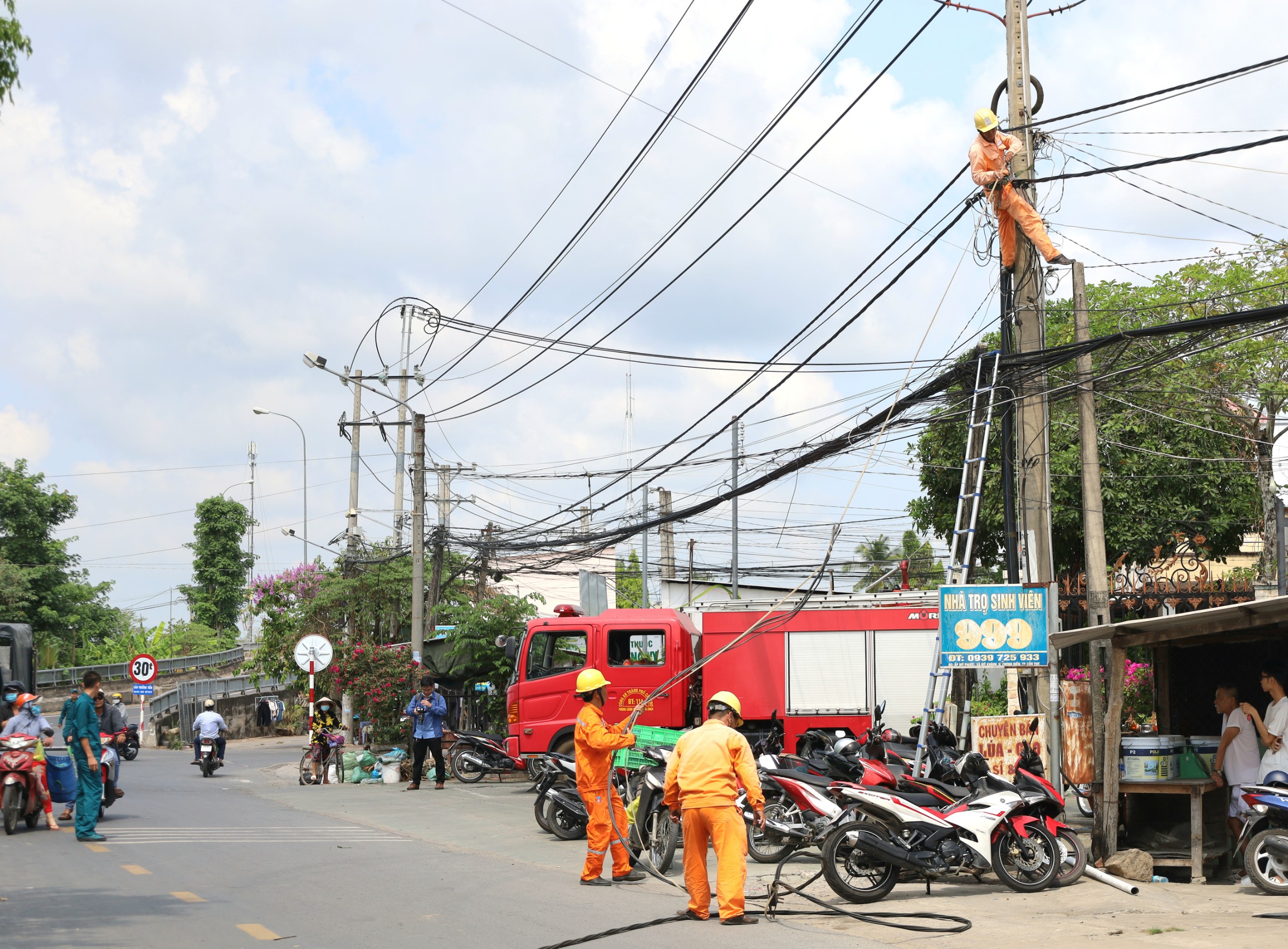 Nhân viên điện lực tháo dỡ dây điện tại khu vực xảy ra sạt lở.