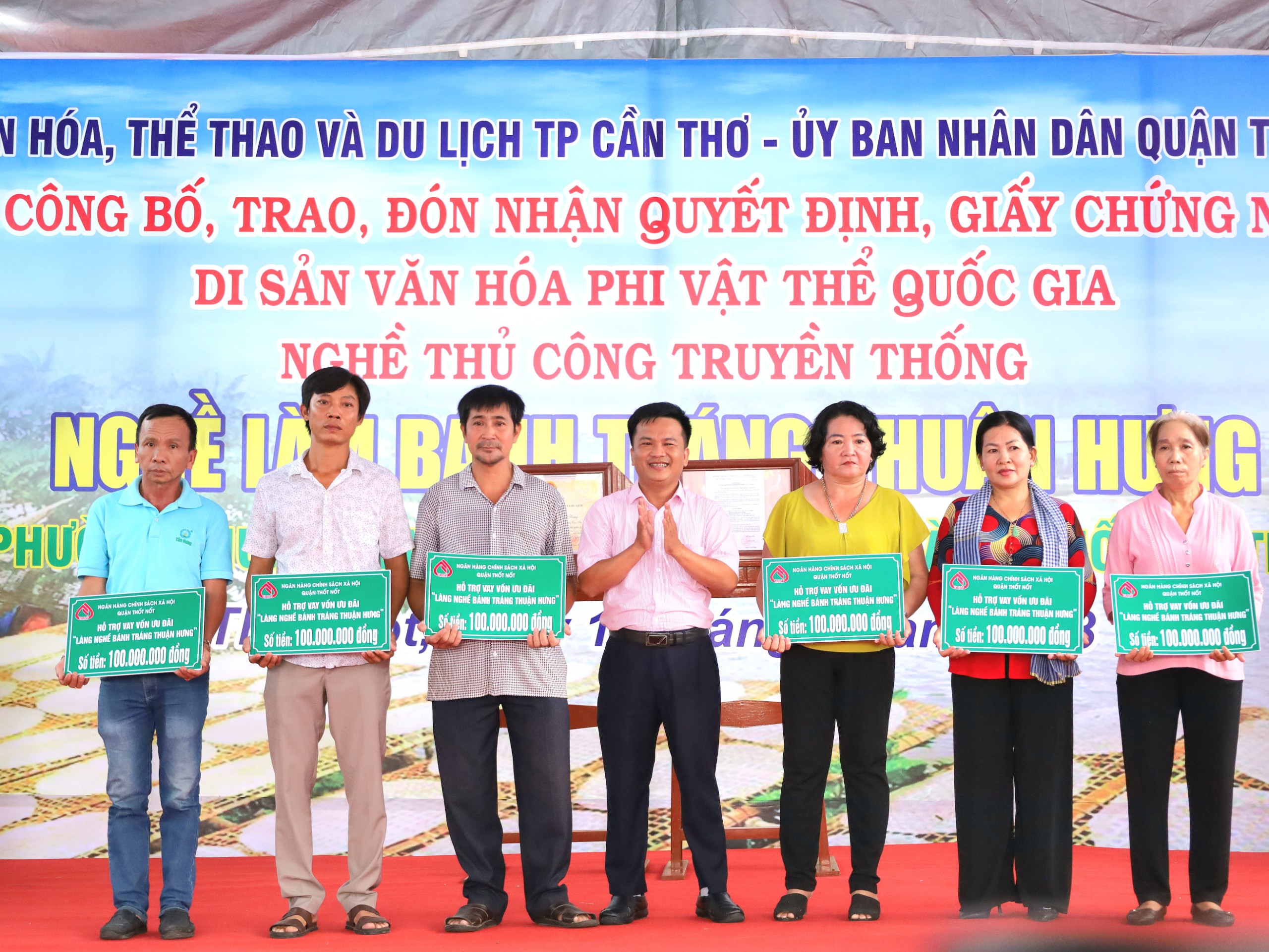 Ông Nguyễn Ngọc Toàn - Phó giám đốc Phòng giao dịch NHCSXH quận Thốt Nốt trao bảng tượng trưng nhận tiền vay cho các gia đình Làng nghề bánh tráng Thuận Hưng.