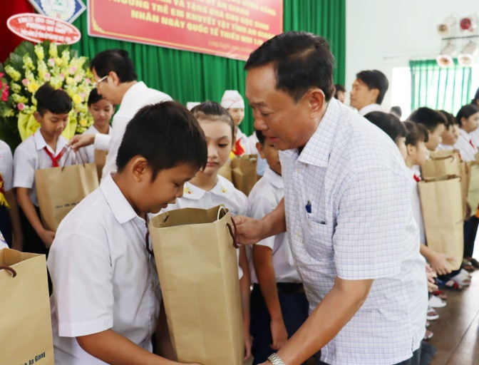 Chủ tịch Ủy ban MTTQ Việt Nam tỉnh An Giang Nguyễn Tiếc Hùng trao quà cho các học sinh.