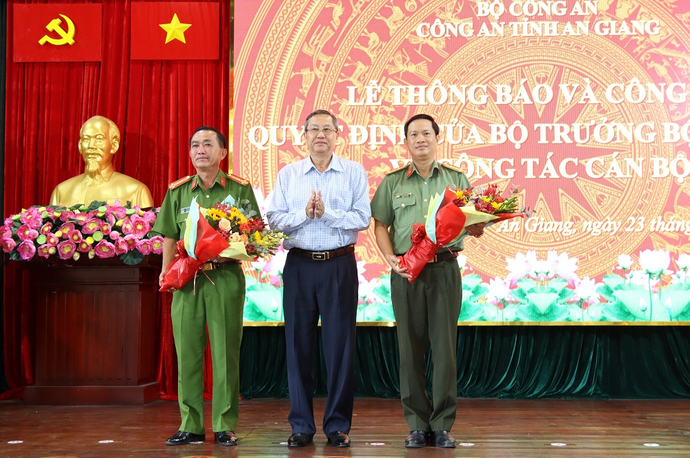 Ông Lê Văn Nưng - Phó Bí thư Thường trực Tỉnh ủy, Chủ tịch HĐND tỉnh An Giang tặng hoa cho Đại tá Bùi Bé Năm và Đại tá Nguyễn Nhật Trường.