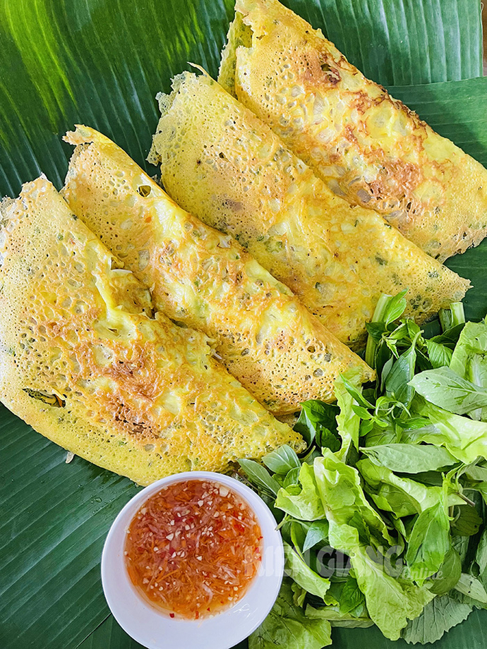 Bánh xèo vàng ươm, giòn tan, có vị ngọt của tôm và vị béo của thịt ba chỉ, ăn kèm rau sống chấm nước mắm chua ngọt.