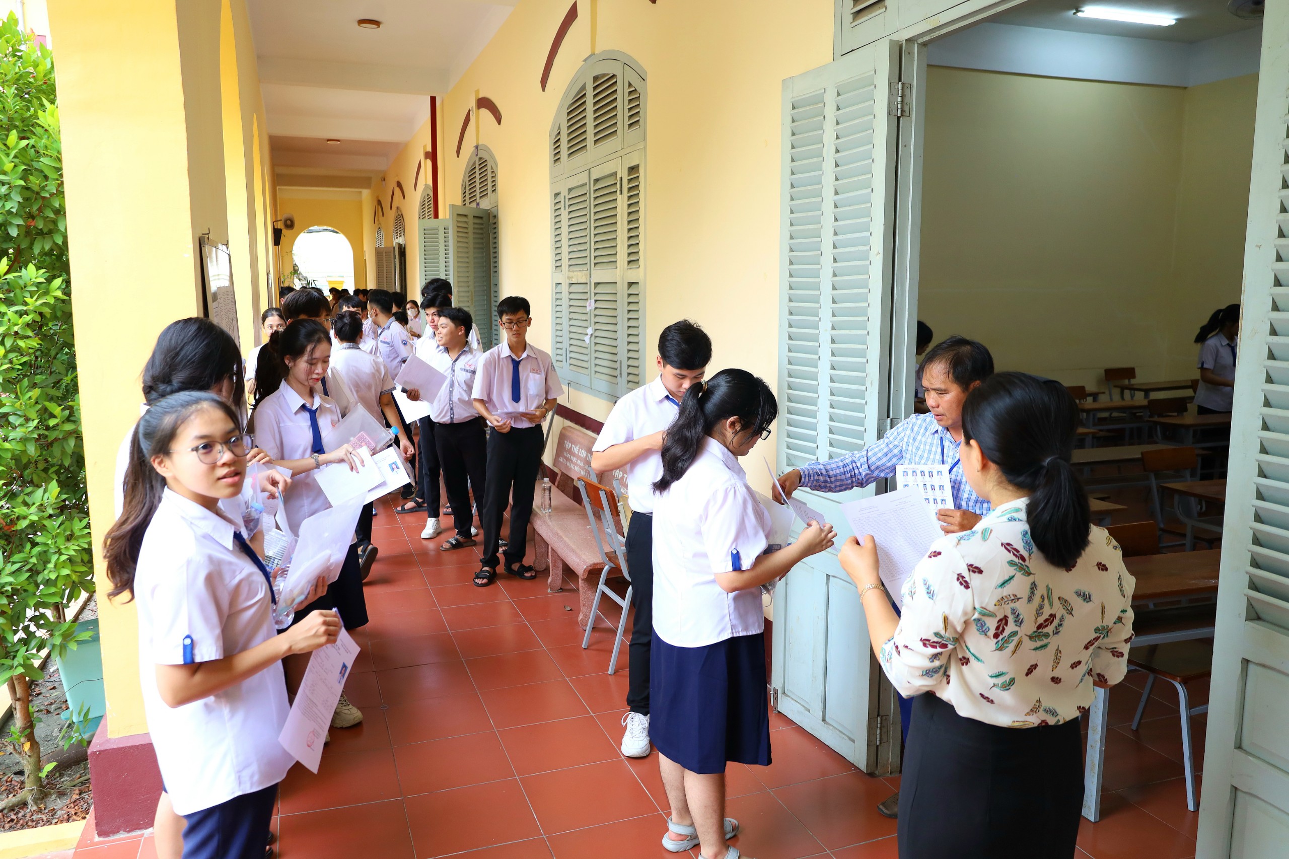 Các thí sinh làm thủ tục vào phòng thi tại điểm thi Trường THPT Châu Văn Liêm.