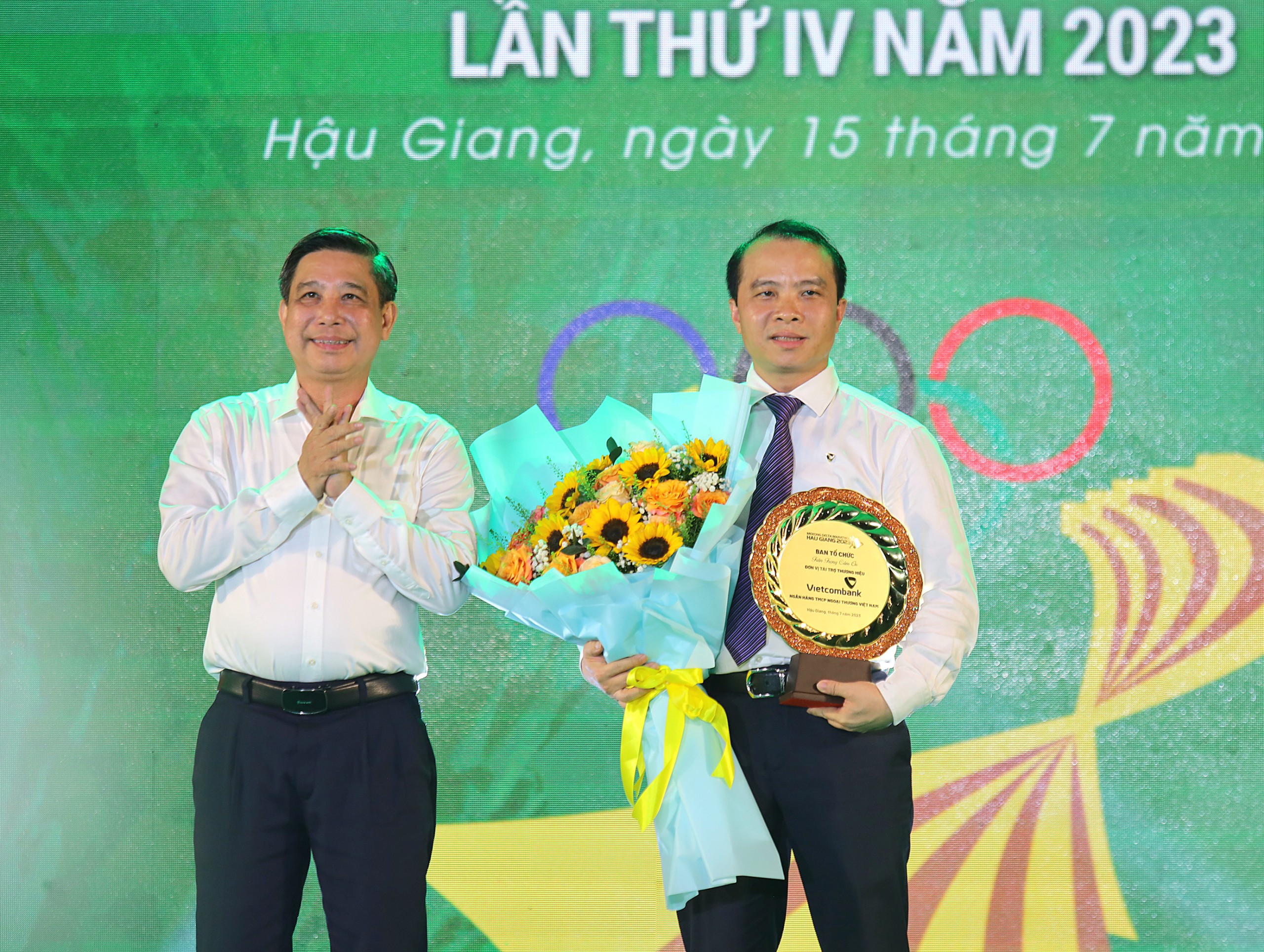 Ông Đồng Văn Thanh - Phó Bí thư Tỉnh ủy, Chủ tịch Ủy ban nhân dân tỉnh Hậu Giang tặng hoa và kỷ niệm chương cho ông Đỗ Việt Hùng - Thành viên Hội đồng quản trị Ngân hàng Vietcombank, nhà tài trợ thương hiệu cho Giải Marathon.