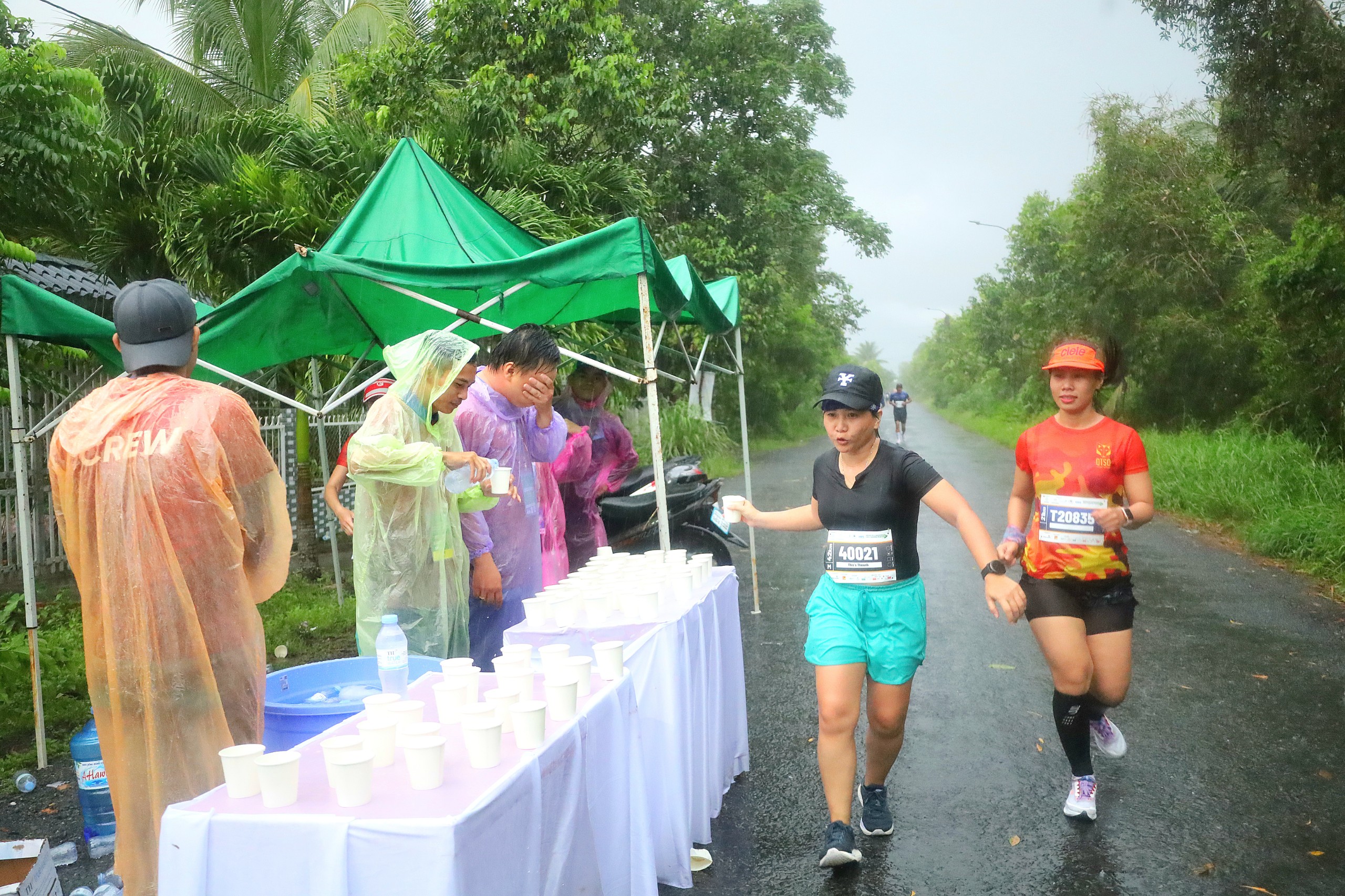 Các tình nguyện viên đội mưa hỗ trợ vận động viên.