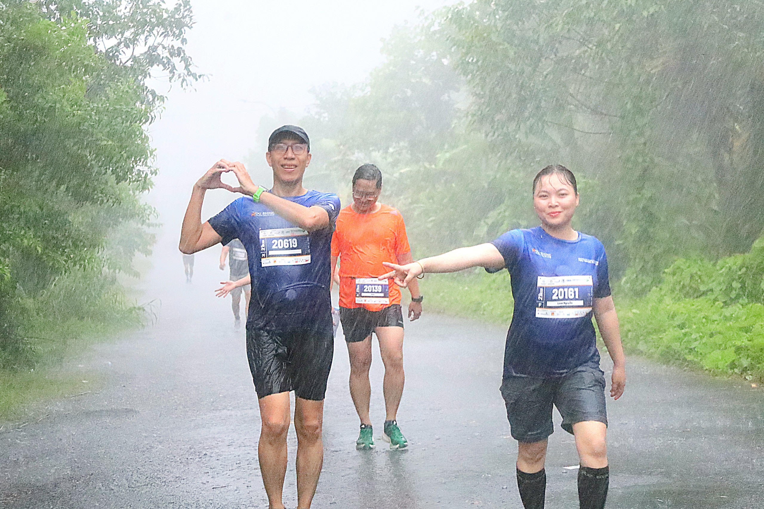 Các vận động viên vui vẻ trên đường chạy cự ly 21km mặc cho mưa rất lớn.