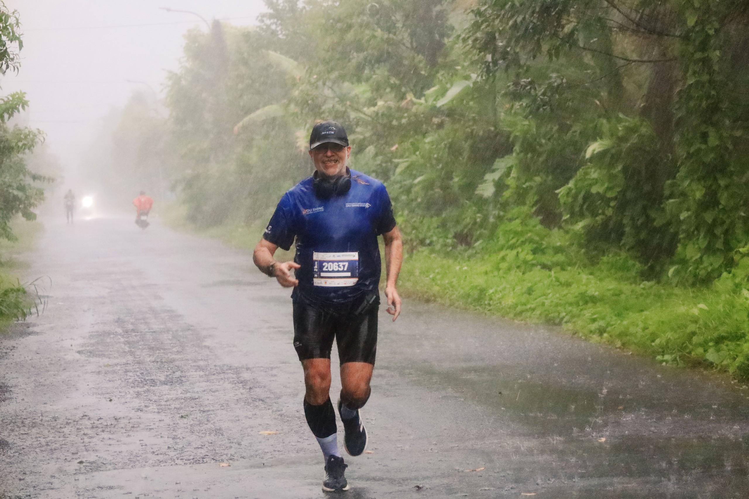Một vận động viên nước ngoài tham gia đường chạy 21km, mặc dù thời tiết mưa lớn nhưng không làm khó được những bước chân đam mê marathon.