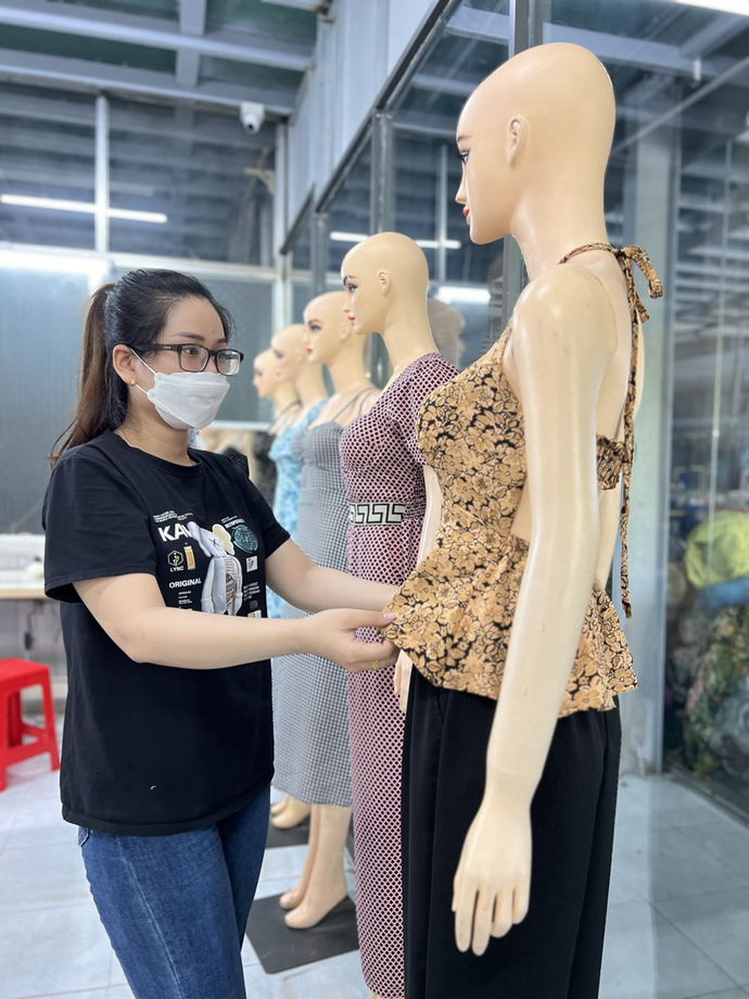 Chị Tiêu Hồng Cẩm, nhân viên thiết kế rập vải đang xem lại mẫu Áo yếm đang thịnh hành trên thị trường trong mùa hè này.