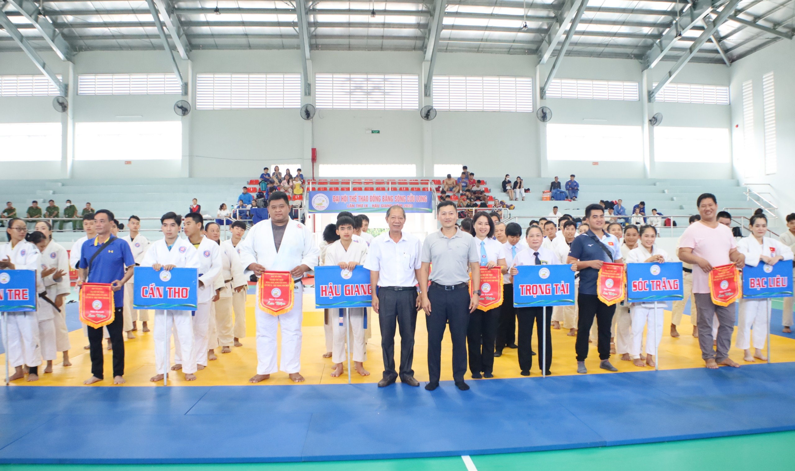 Ông Nguyễn Hữu An - Phụ trách môn Judo, Kurash - Cục TDTT và ông Bùi Việt Hà – Phó Chủ tịch UBND TP. Ngã Bảy tặng cờ lưu niệm cho các đoàn tham dự giải.