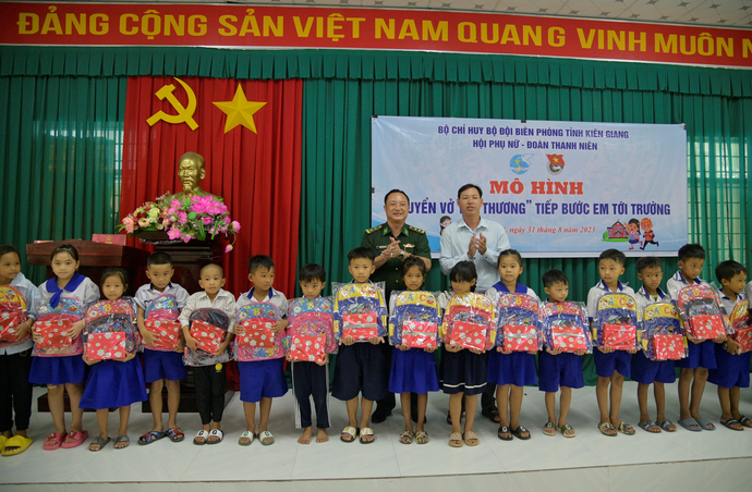 Các đoàn viên, thanh niên, hội Phụ nữ BĐBP tỉnh Kiên Giang trao cặp, sách cho các em học sinh nghèo ở xã Phú Lợi, huyện Giang Thành