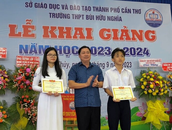 Ông Nhâm Văn Tám - Phó Trưởng ban đại diện Cha mẹ học sinh trao thưởng cho em Ngọc Hà và Phú Sang - Học sinh có điểm thi tốt nghiệp THPT năm 2023 cao nhất trường và học sinh thủ khoa đầu vào Kỳ thi tuyển sinh vào lớp 10 THPT năm học 2023-2024.
