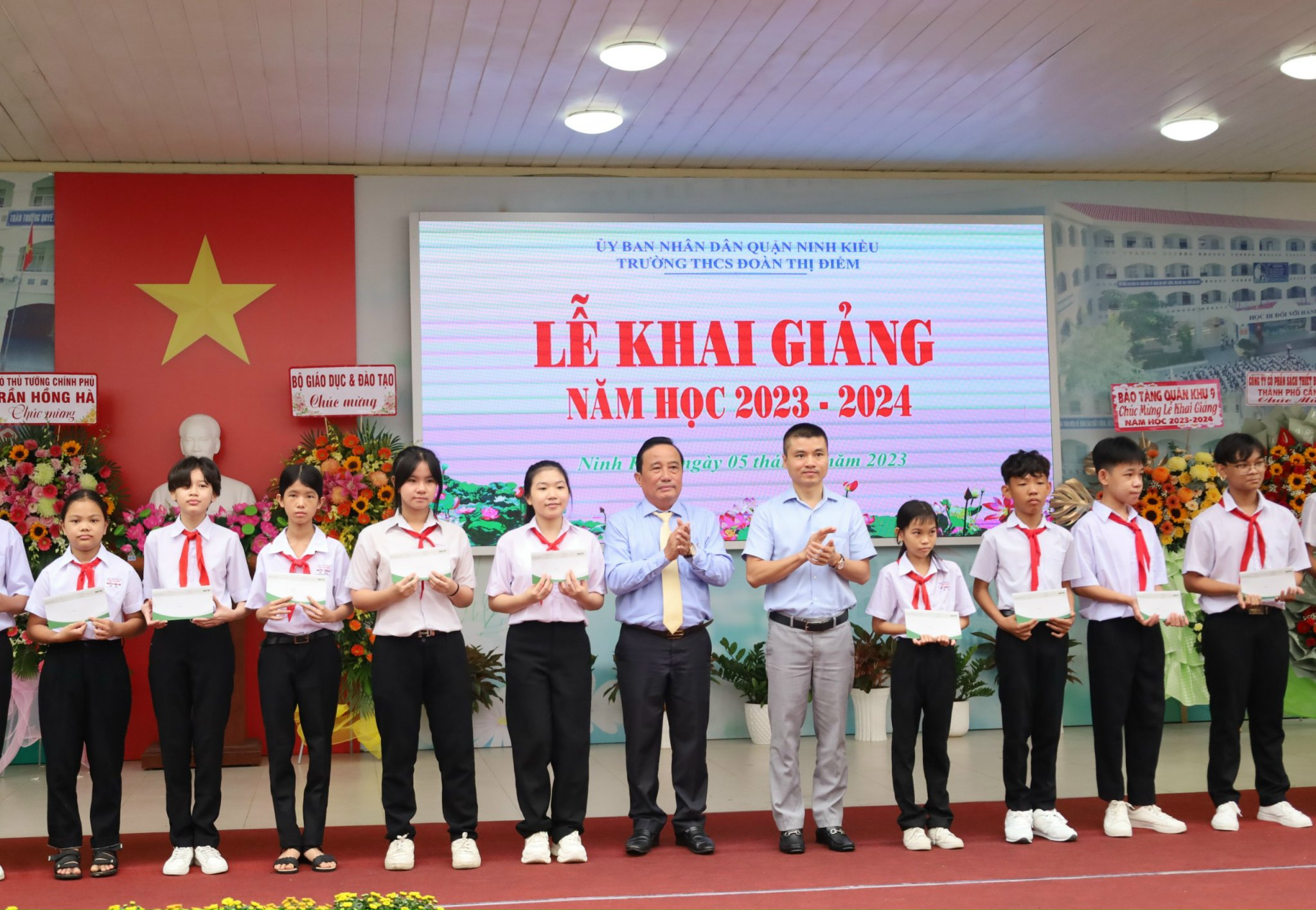 Nhà báo Phạm Tuấn Anh - Tổng biên tập Báo Dân trí và ông Nguyễn Tiền Phong – UV BTV Thành ủy, Bí thư Quận ủy Ninh Kiều trao tặng quà cho các em học sinh.