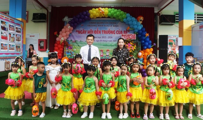 Ông Hoàng Quốc Cường, Giám đốc Sở Y tế chụp ảnh lưu niệm cùng thầy cô và các em học sinh Trường Mầm non Lê Bình.
