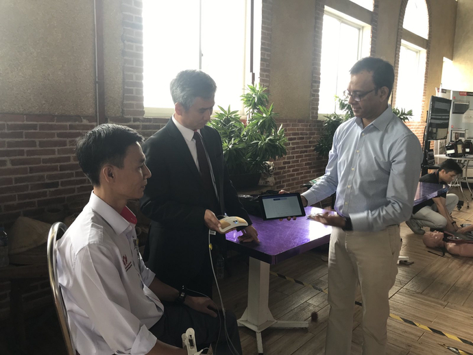 Ông Trần Chí Cường giới thiệu máy đo điện tim hiện đại truyền dữ liệu từ người bệnh tại nhà đến Trung tâm Y tế.