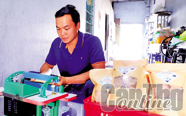 Anh Ðỗ Hoàng Giao, chủ cơ sở sản xuất bánh đa, hủ tiếu Nhật Nguyệt, đóng gói bao bì sản phẩm bánh đa đồng tiền.
