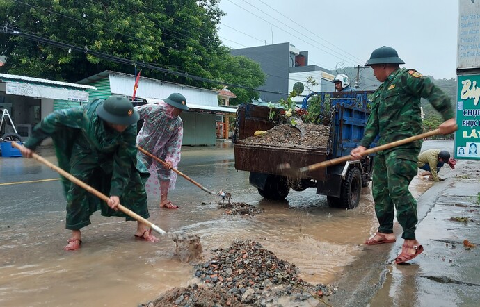 Cán bộ chiến sĩ đồn Biên phòng Hòn Chông tham gia thu dọn đất, đá trên các tỉnh lộ thuộc huyện Kiên Lương