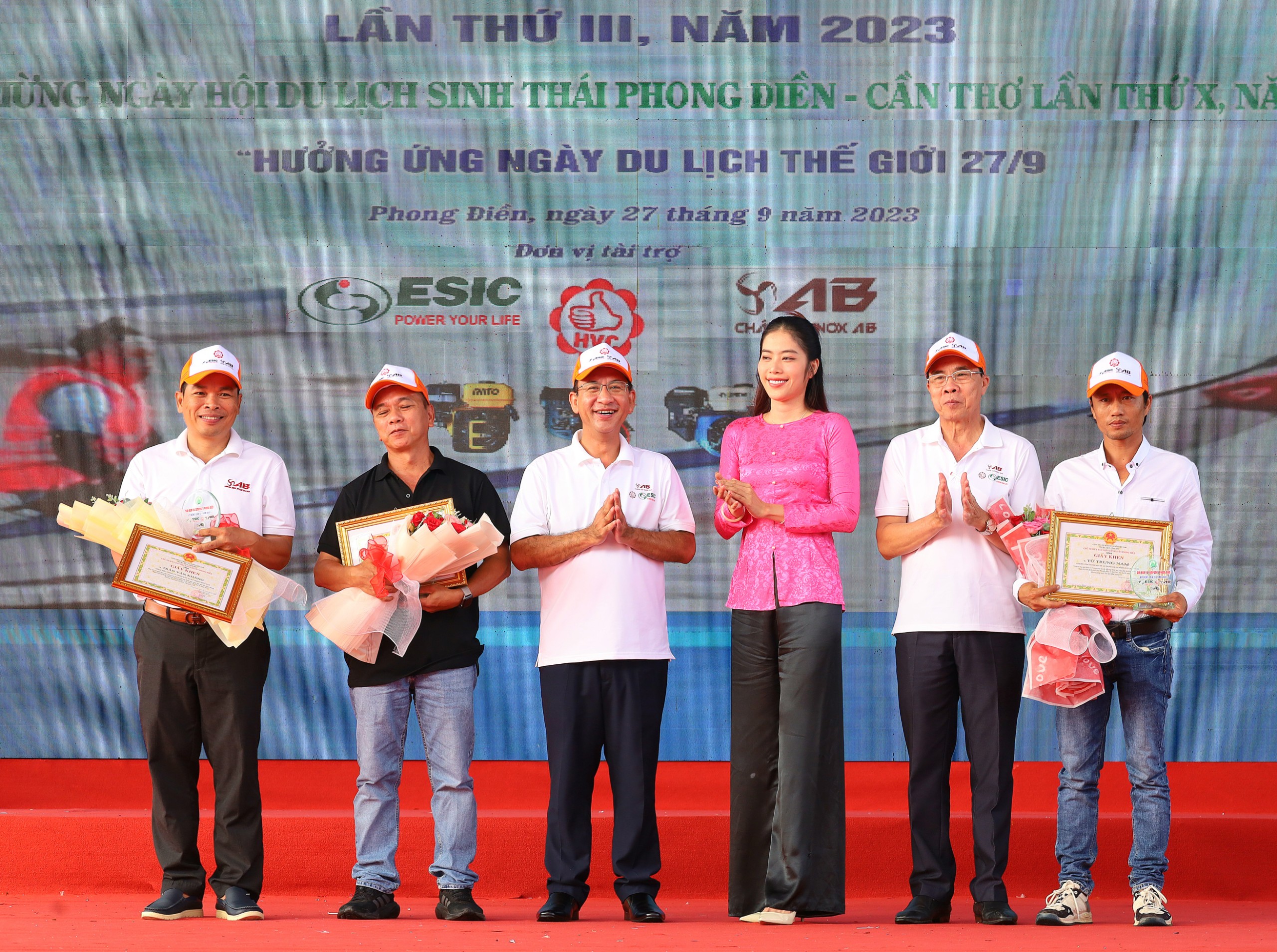 Ông Đào Ngọc Chi - Bí thư Huyện ủy Phong Điền, ông Nguyễn Trung Nghĩa - Chủ tịch UBND huyện Phong Điền và Hoa hậu Nam Em trao tặng giấy khen, hoa cho các đơn vị tài trợ.