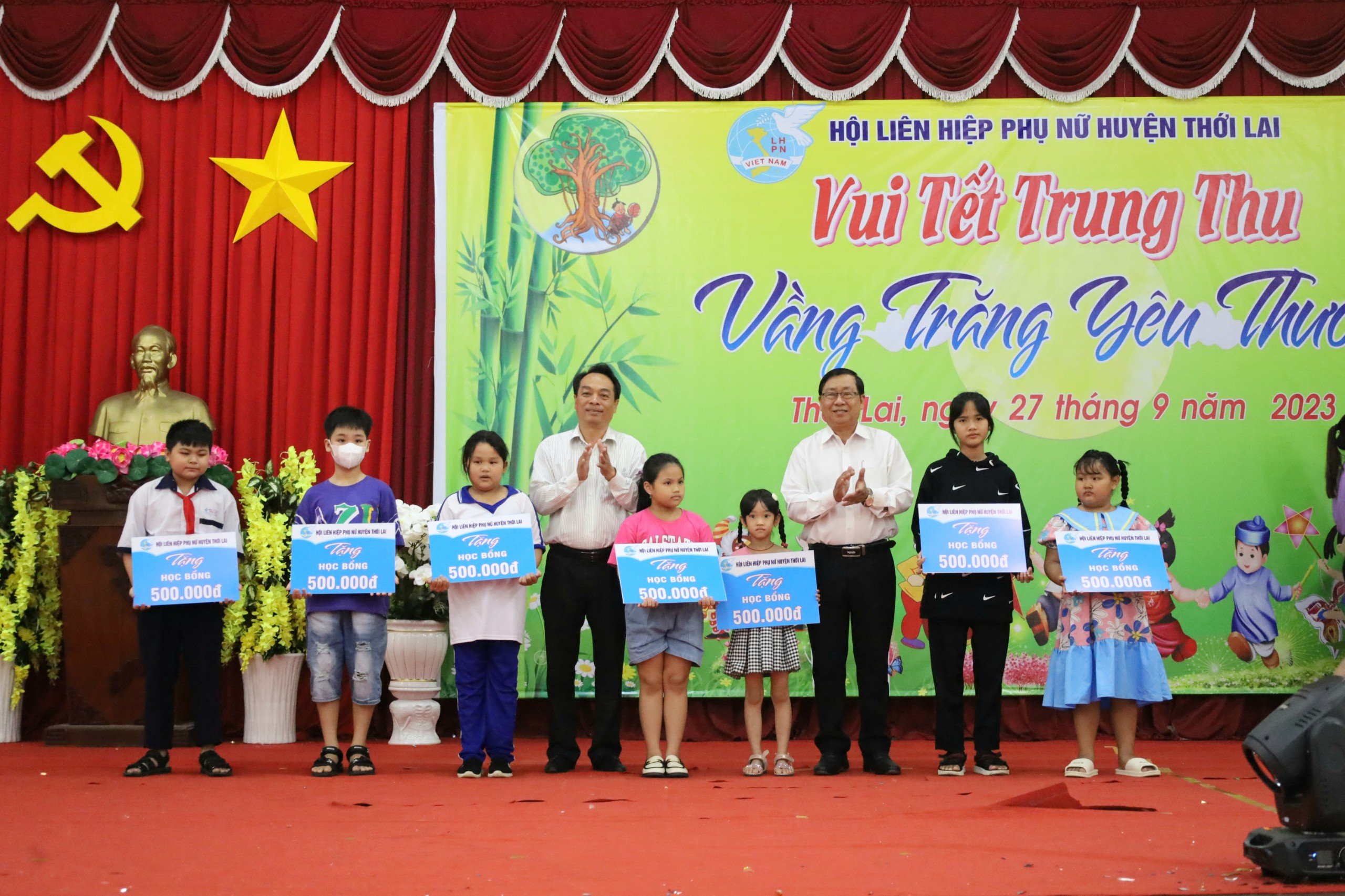 Ông Lê Tiến Dũng - Phó Chủ tịch thường trực HĐND huyện và ông Nguyễn Văn Hoàng - Phó Chủ tịch thường trực UBND huyện Thới Lai trao tặng học bổng cho các em thiếu nhi.