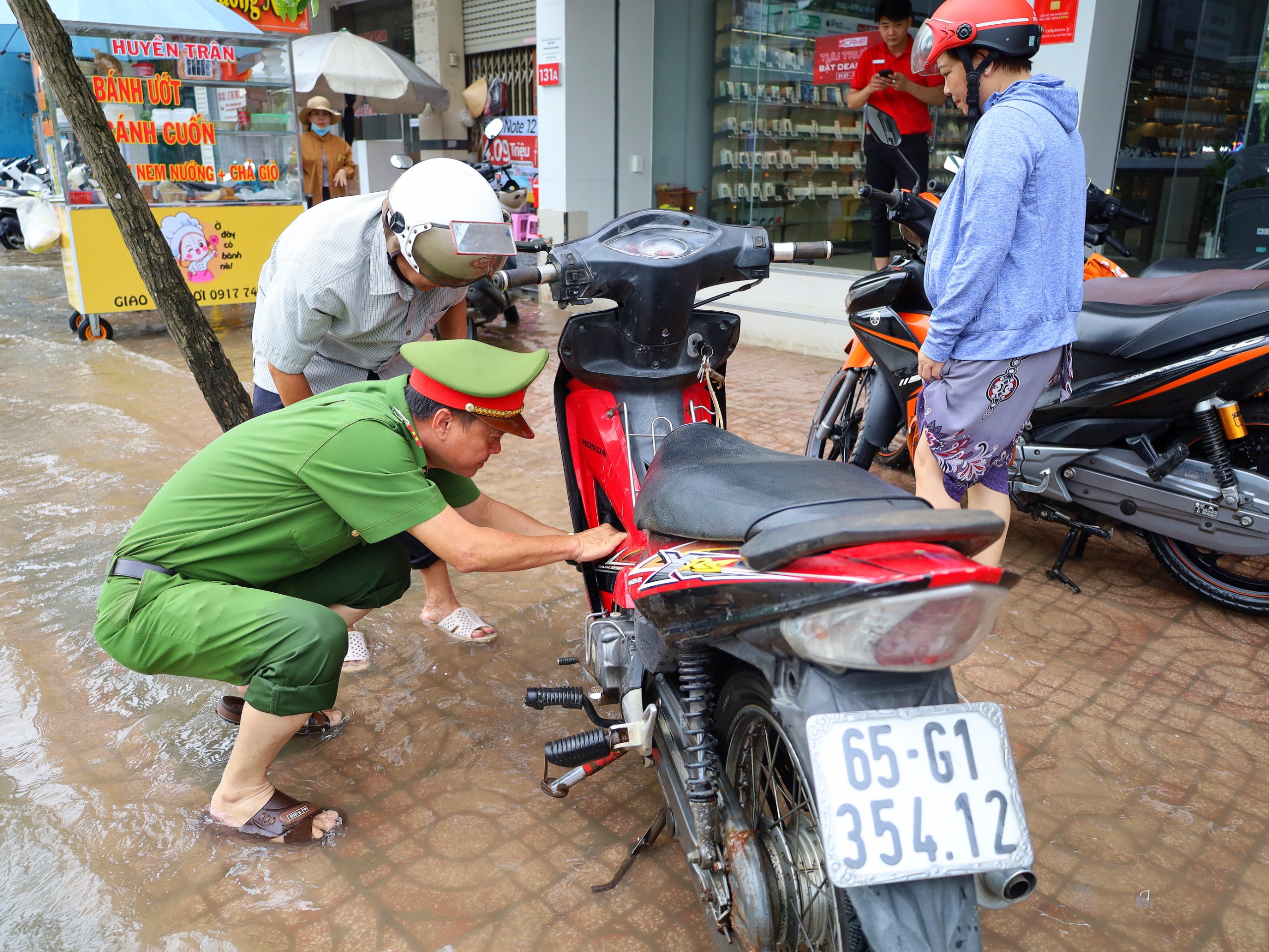 Lực lượng công an TP. Cần Thơ kiêm luôn thợ sửa xe hỗ trợ người dân.