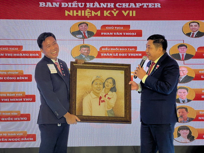 Chủ tịch BNI Riverside NK VII, Phan Văn Thoại (bìa phải), trao tặng bức tranh vinh danh công lao của người vợ hiền thảo đối với sự nghiệp thành công của doanh nhân Chủ tịch NK6, Trần Ngọc Phụng.