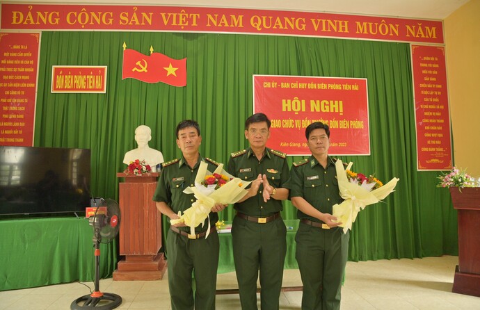 Đại tá Huỳnh Văn Đông thăm, trao hoa chúc mừng Thượng tá Nguyễn Tiến Sự (bên trái) được Quân đội cho về nghỉ hưu và giao nhiệm vụ mới cho Thiếu tá Sơn Trung Hiếu (bên phải) phụ trách đồn trưởng đồn BP Tiên Hải.